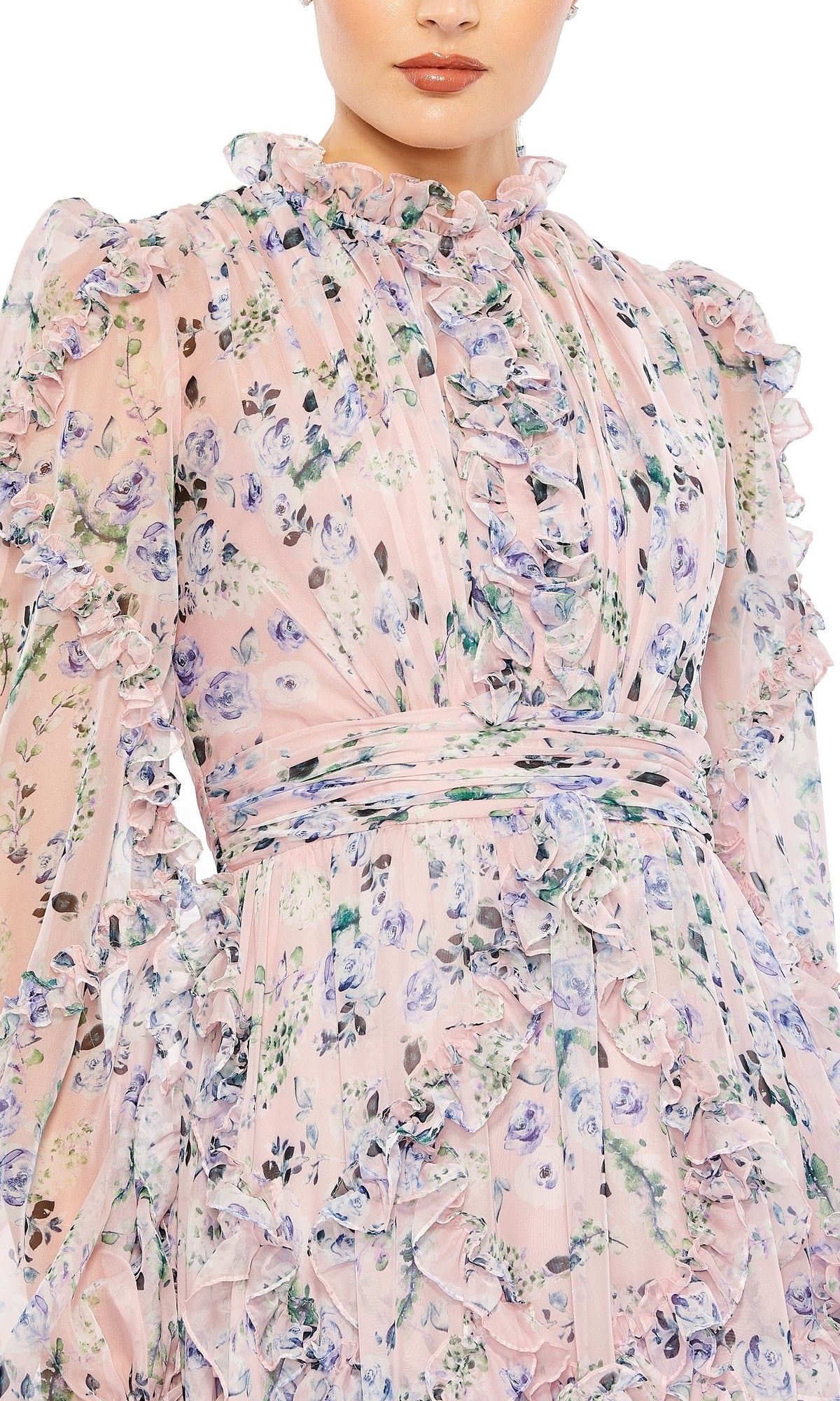 A woman wears the Long Formal Dress 68232 by Mac Duggal, a blush gown with long sleeves, blue and purple floral patterns, ruffles, and a high neckline.